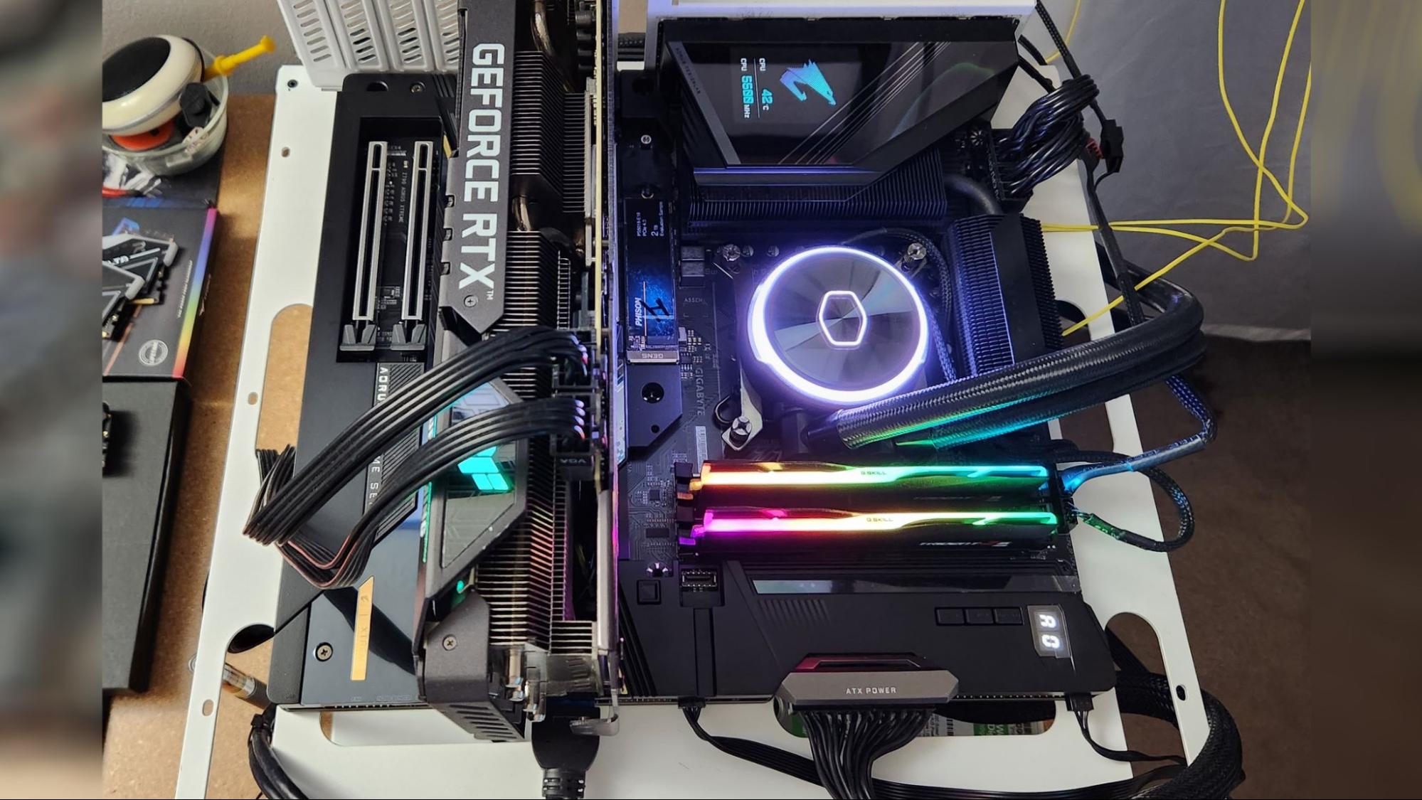 Gigabyte Z790 Aorus Xtreme находится в нашем открытом тестовом стенде во время тестирования производительности. Обратите внимание на цветной дисплей над VRM, который может показывать статистику системы вместе с логотипом Aorus falcon.