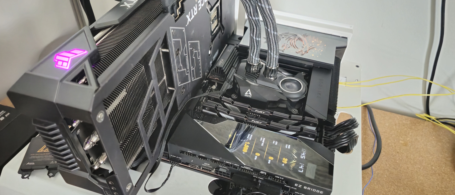 Флагманская плата MSI Z890 Godlike находится в нашем открытом тестовом стенде, пока мы проводим тесты производительности. На EZ Bridge, расположенном вдоль переднего края, интегрированный 4-дюймовый дисплей показывает статистику мониторинга системы, хотя вы также можете добавить свое собственное изображение.